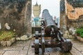 Ancient cannon on top platform of The Mount Fortress Museum of History aimed on skyscraper of The Grand Lisboa Hotel