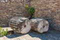 Ancient carved column segments against stone wall Royalty Free Stock Photo