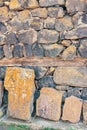 Ancient carved stone slabs with intricate patterns against a rugged wall