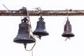 Ancient cast bells hanging from a grungy rusty metal support at an Orthodox monastery in Eastern Europe