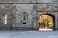 Ancient castle city wall. Arched medieval gate in a stone wall. Sun shining through the stone arch.