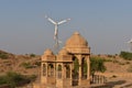 Ancient cenotaph with modern windmills in bada baag Jaisalmer Rajasthan India Royalty Free Stock Photo