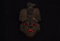An ancient ceramic pre columbus mask based in American indigenous tribes art iluminated by red light inside