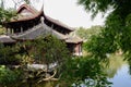 Ancient Chinese building behind bush and trees