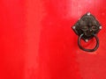 Ancient Chinese door knocker on red wooden door with leaves shadow in sunny day, the Chinese characters on it means lucky Royalty Free Stock Photo