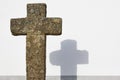 Ancient christian stone cross and white wall background. Copyspace Royalty Free Stock Photo