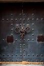 Ancient church door. Close-up of an old black metal door with rings and rivets Royalty Free Stock Photo