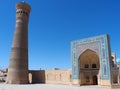 Ancient city under blue sky: square with minaret tower and mosque entrance Royalty Free Stock Photo