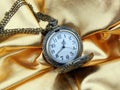 Ancient clock on a gold satin background Royalty Free Stock Photo