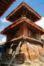 An ancient collapsing Hindu three-story temple on a stone pedestal with wooden pillars. Durbar Square in Kathmandu, Nepal Royalty Free Stock Photo