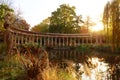 The ancient columns of Parc Monceau are reflected in the water of the oval basin, in the sun . This public garden is located in Royalty Free Stock Photo