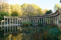 The ancient columns of Parc Monceau are reflected in the water of the oval basin, in the sun . This public garden is located in Royalty Free Stock Photo