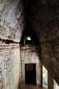 Ancient corridor with a vaulted stone ceiling. Ancient stone construction. Door hole in the stone wall