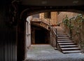 Ancient courtyard with a staircase and plants growing in the walls in Spain, Girona