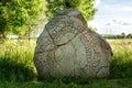 Ancient and cracked rune stone with summer background Royalty Free Stock Photo