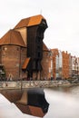 Ancient crane - zuraw Old town in Gdansk. The riverside on Granary Island reflection in Moltawa River. Visit Gdansk