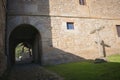 Ancient cross near arch entrance to the castle. Stone old crucifix on monastery backyard. Christianity symbols. Medieval cemetery. Royalty Free Stock Photo