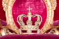 Ancient crown on red velvet. Antique symbol of authority, luxury, monarchy, nobility