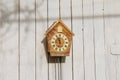 Cuckoo clock hanging on a light wooden background. About twelve o'clock. Royalty Free Stock Photo