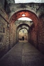 Ancient deserted alley in Jewish Quarter in the Old City Jerusalem with switched on street light on the vault. Old narrow street Royalty Free Stock Photo