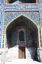 Ancient doors and a fragment of a wall decorated with mosaics to the Sherdor Madrasah at Registan Square in Sarkand in Uzbekistan