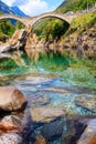 Ancient double arch stone Roman bridge (Ponte dei Salti) over clear water of the Verzasca river in Verzasca Valley Royalty Free Stock Photo