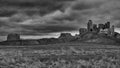 Ancient Duffus castle ruins atop a rocky hill, surrounded by clouds and overcast skies