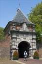 Ancient Dutch city gate Veerpoort and senior cyclist