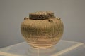 Ancient earthenware jar in a museum with simple circular patterns drawn on it from prehistoric times