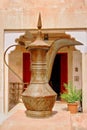 Ancient eastern craft pitcher, of copper or brass, painted in traditional patterns. Outdoors in Central Asia.