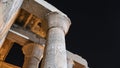 Ancient Egyptian columns against a dark night sky with stars