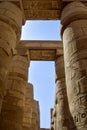 Ancient Egyptian hieroglyphs and symbols carved on columns of the complex of Karnak temple. Tall columns against blue sky. Royalty Free Stock Photo