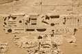 Ancient Egyptian hieroglyphs and symbols carved in stone, preserved fragments in complex of the Karnak temple Royalty Free Stock Photo