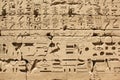 Ancient Egyptian hieroglyphs and symbols carved in stone, wall decoration of the complex of the Karnak temple Royalty Free Stock Photo