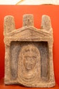 Ancient etruscan relic made of carved stone with a female face engraved Royalty Free Stock Photo