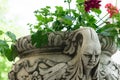 Ancient flower pot holder made from brute stone. very old sculpture with scarry face - gothic style