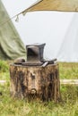 Ancient forge anvil and a hammer on the stump. Forge under the open sky