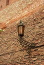 An ancient forged lantern on a red brick wall. Ancient fortress,history.