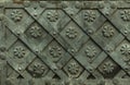 Ancient forged metal texture with decorative overlays. Doors, gates, shutters. Detail of a medieval gray door with metal decoratio