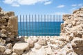 Ancient fortress wall with sea view through the grill