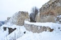 Ancient fortress wall and tower covered with snow, the wall is made of stone and limestone