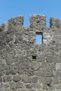 Wall of an ancient stone fortress with windows. Royalty Free Stock Photo