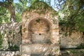 Ancient fountain in ruins among the trees