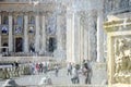 The ancient fountain surrounded by tourists. St. Peter`s Square is located in front of St. Peter`s Basilica in the Vatican City Royalty Free Stock Photo