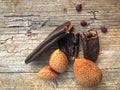 The ancient fruit of carobs and a bunch of almonds on a wooden background from Royalty Free Stock Photo
