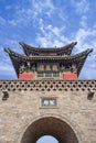 Ancient gate with pagoda againts a blue sky with dramatic clouds, Pingyao, China