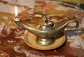 ancient gilded oil lamp with lit flame