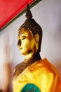 An ancient gilded statue of Buddha in yellow robes