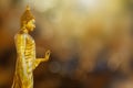 Ancient golden Buddha statue on blurred golden bokeh background