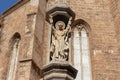 Ancient gothic statue of a priest on the exterior of a gothic church in Valencia